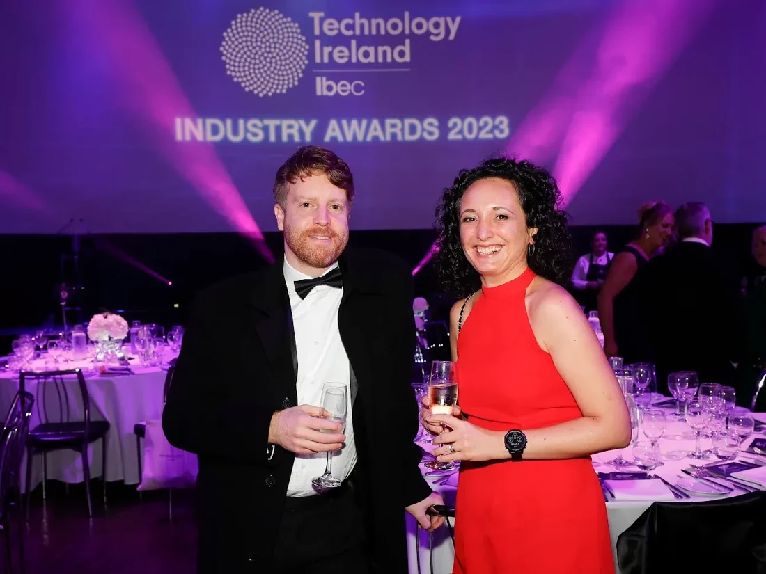 Two members of the EpiSensor team at an awards dinner, under a projected screen reading Technology Ireland Industry Awards 2023.