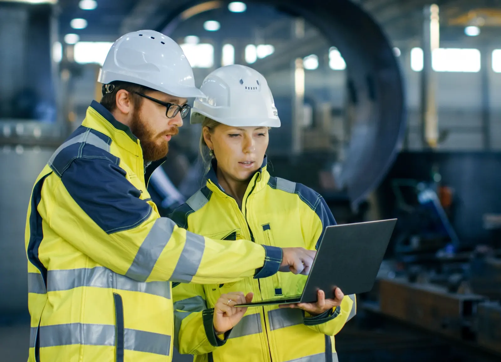 Engineers reviewing a project on the factory floor. Illustrative stock photography.