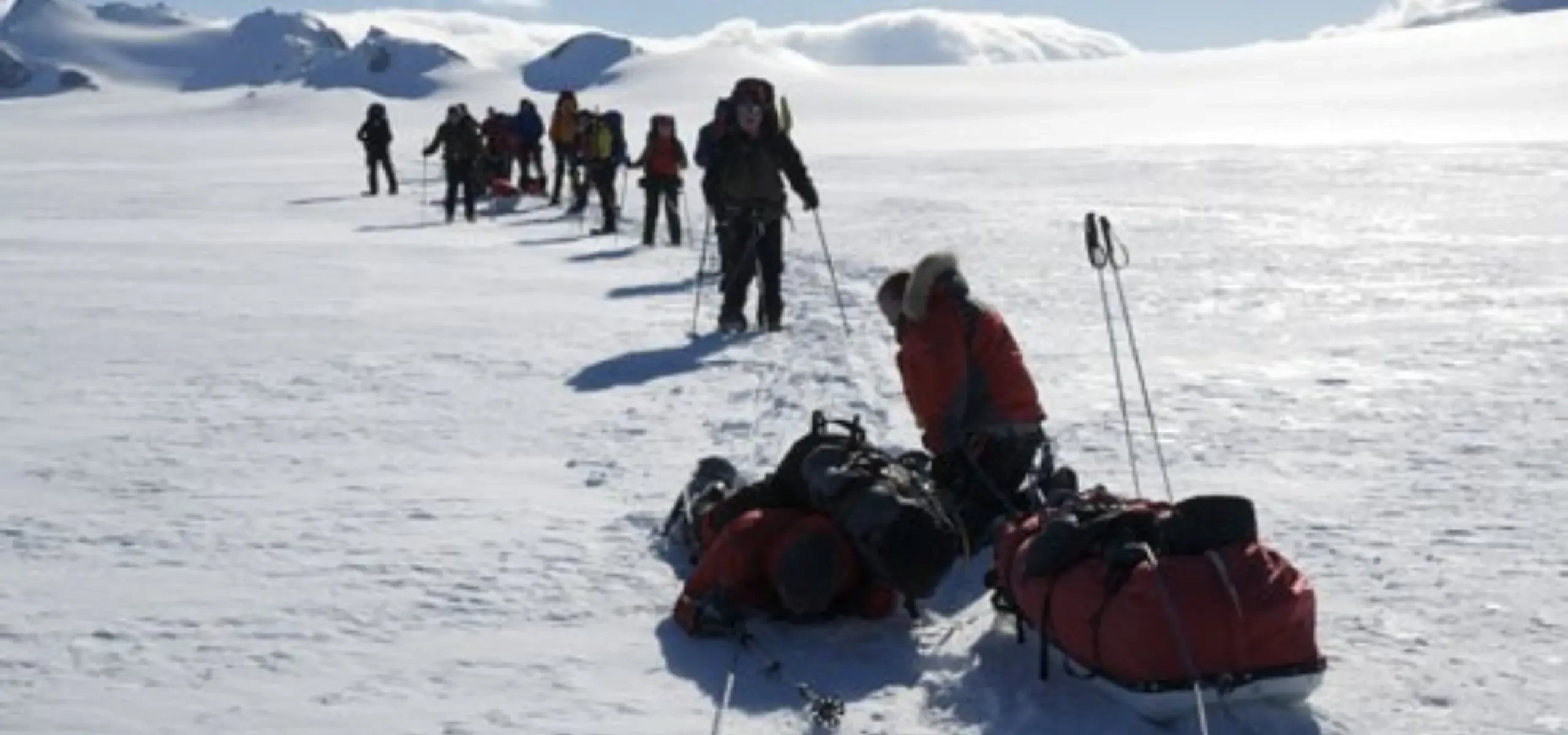 An expedition party hauling sledges across the ice in Antarctica.
