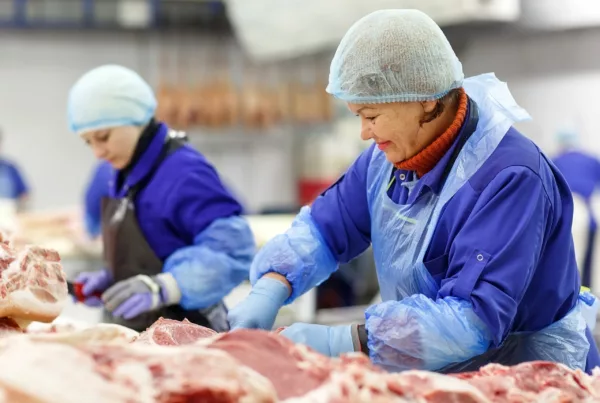 Employees manage inventory at commercial meat processing plant. Source: Canva.